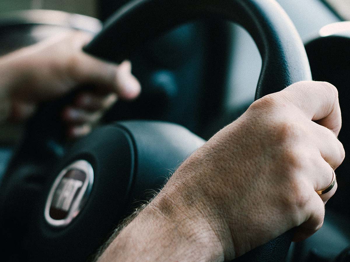 image of hands closeup holding the steering wheel. 