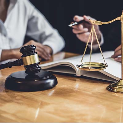 A truck accident attorney talking with a client with a gavel and a scale in the foreground.