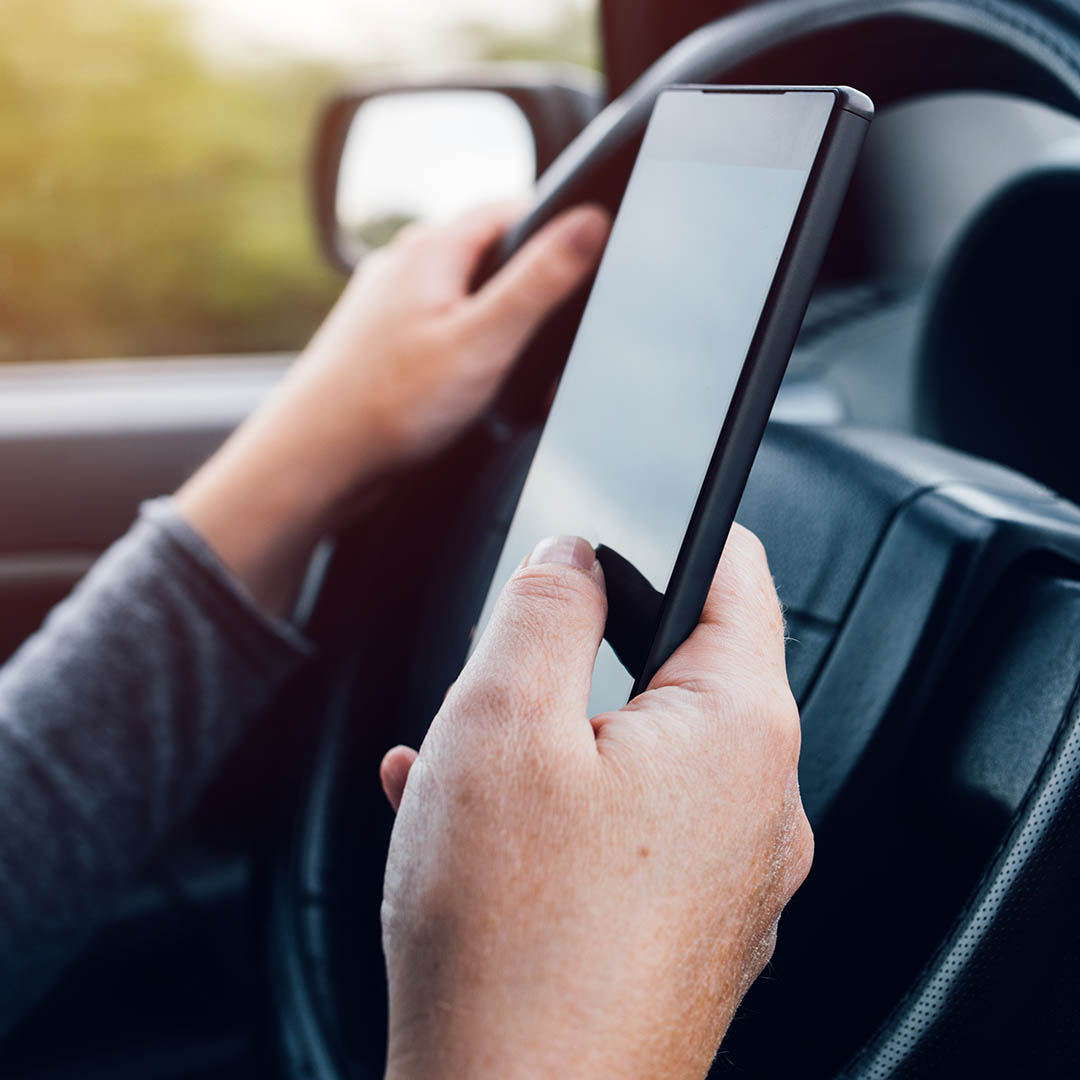 man distracted by texting while driving